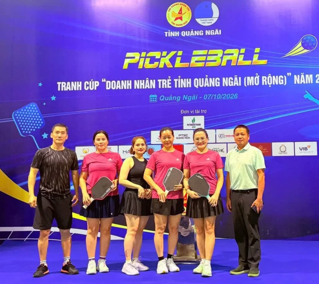 Nhóm vận động viên nữ cầm vợt Pickleball chụp hình tại khu vực tổ chức giải.